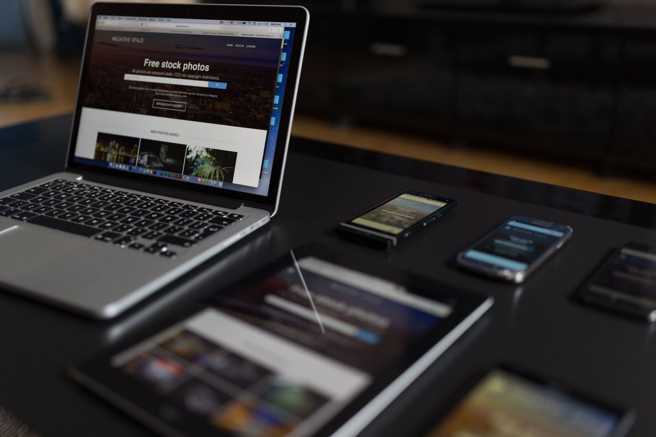 about-us Un espace de travail contemporain présentant un ordinateur portable, une tablette et des smartphones, idéal pour un usage tech et freelance.